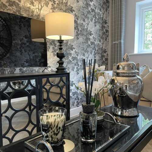 Silver and grey themed living room with glass coffee table, diffuser and silver ornamental vase