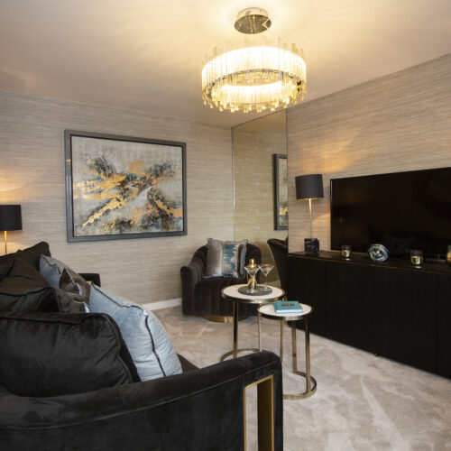 Cream show home living room with black furniture and modern art pieces