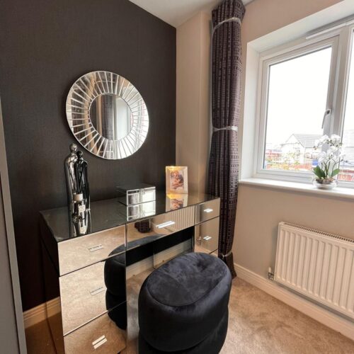 An elegant dressing table with mirrored furniture to reflect light into the room